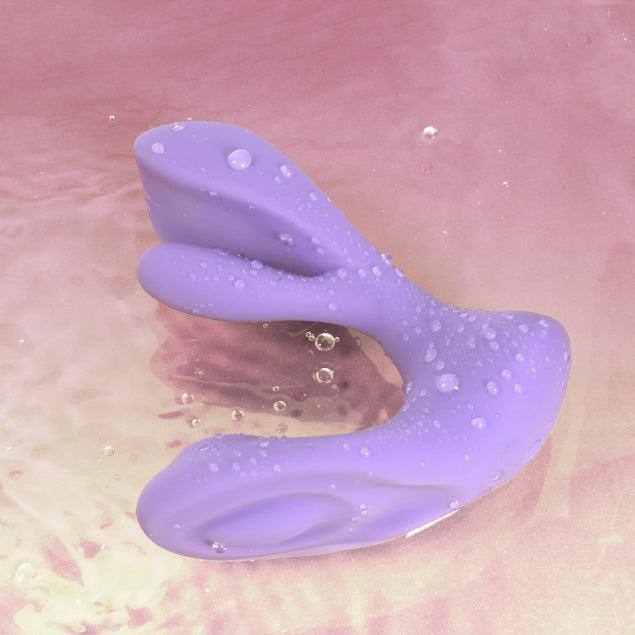 Purple wearable swing vibrator with dual stimulation design on pink background