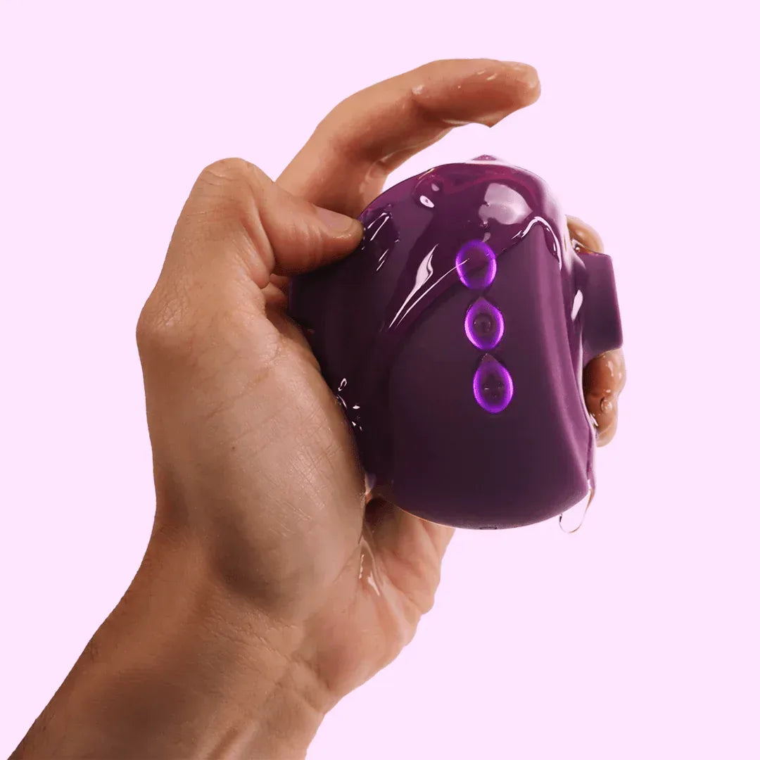 Purple OG 3 clitoral sucking vibrator with three control buttons, held in hand